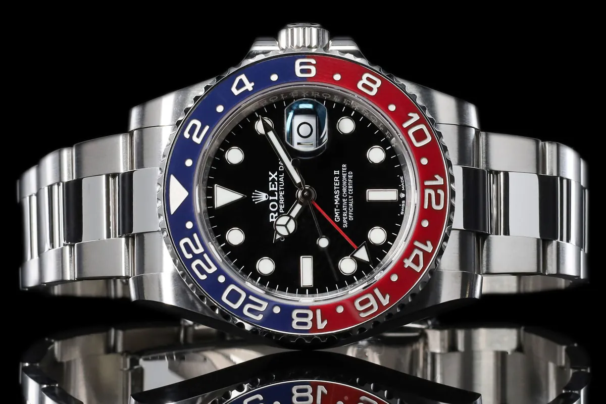Twee stalen horloges met blauw-rode en blauwe bezel naast elkaar